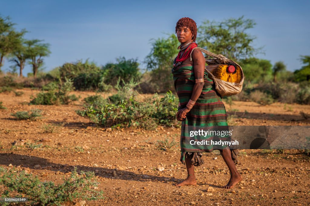 Giovane donna africana che trasporta acqua dal pozzo, Etiopia, Africa