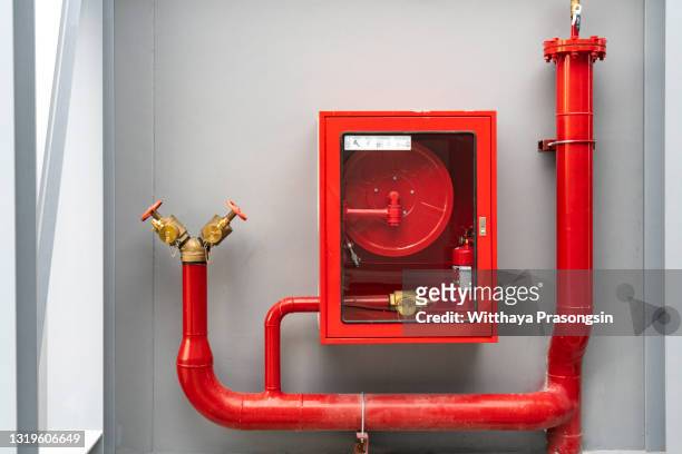 fire extinguisher and fire hose reel in hotel corridor - brandslang bildbanksfoton och bilder