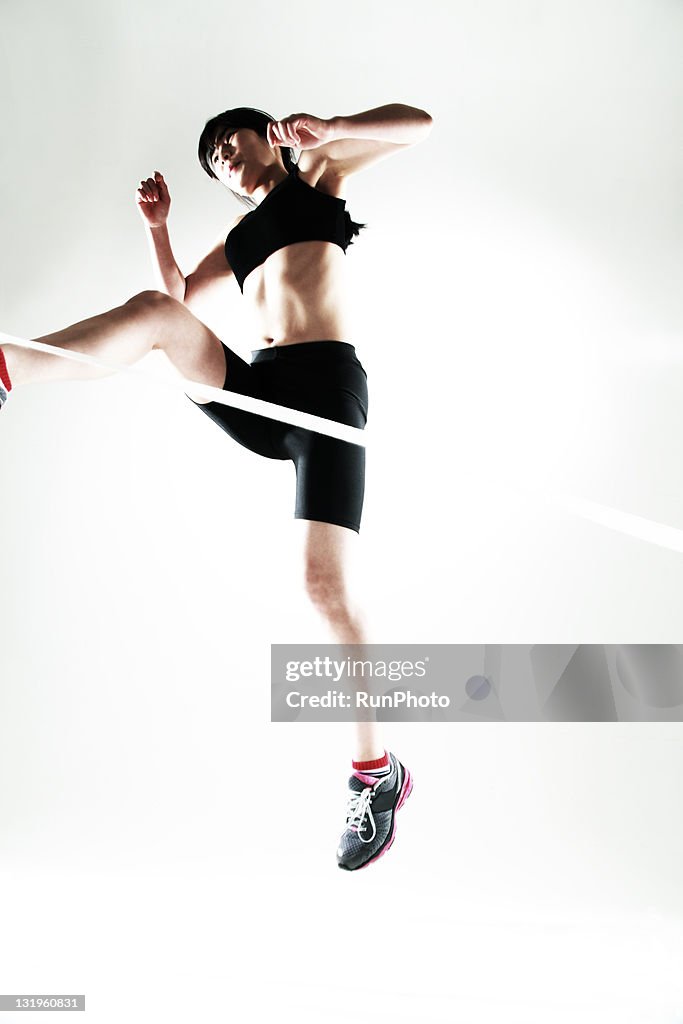 Young woman jumping over the white line