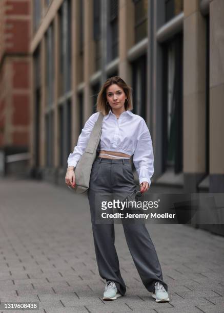 Elise Rozay wearing grey Pull&Bear pants and white blouse, Rayban shades, grey Copenhagen Studios bag and Copenhagen Studios sneakers via The Wants...