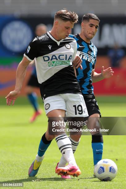 Achraf Hakimi of FC Internazionale battles for possession with Jens Stryger Larsen of Udenese Calcio during the Serie A match between FC...