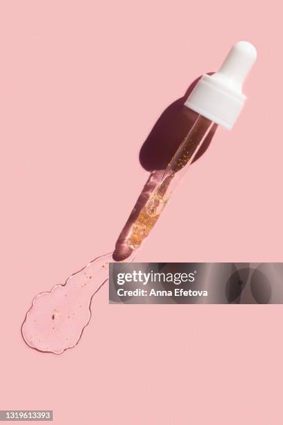 drops of facial serum or essential oil with pipette on pink background. trendy products of the year. health and wellness concept - pipette stock pictures, royalty-free photos & images