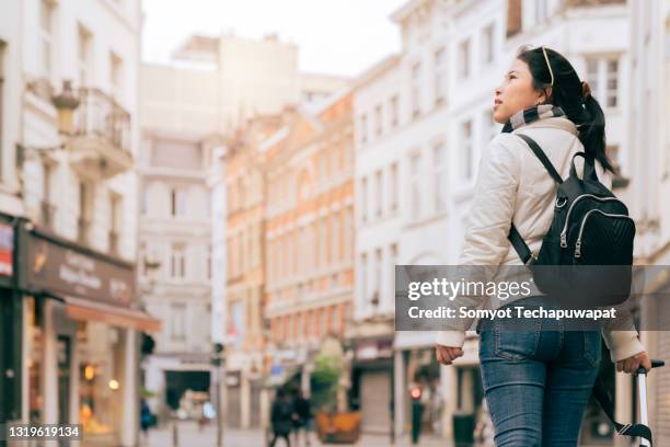 young asian female traveller walking sight seeing at brussels, belgium - grand place stock-fotos und bilder