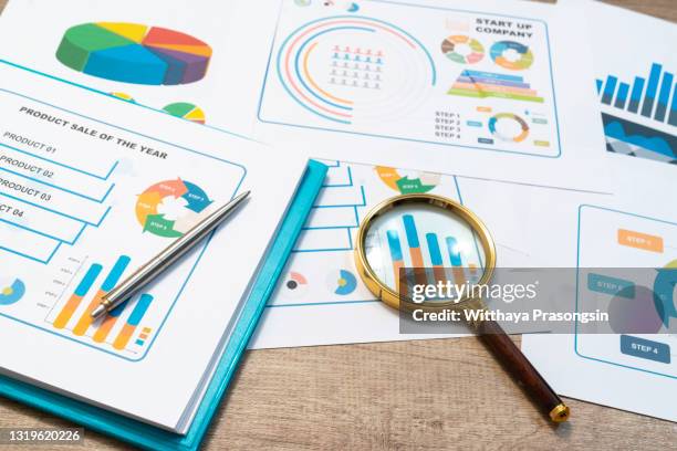 magnifying glass and documents with analytics data lying on table,selective focus - presentation materials stock pictures, royalty-free photos & images