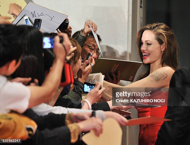 Actress Angellina Jolie is welcomed by fans upon her arrival at the Japan premiere of her partner Brad Pitt's latest film "Moneyball' in Tokyo on...