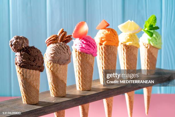 cones de waffle de sorvete variados em uma linha colorido sabor diferente em madeira rosa e azul - seasoning - fotografias e filmes do acervo