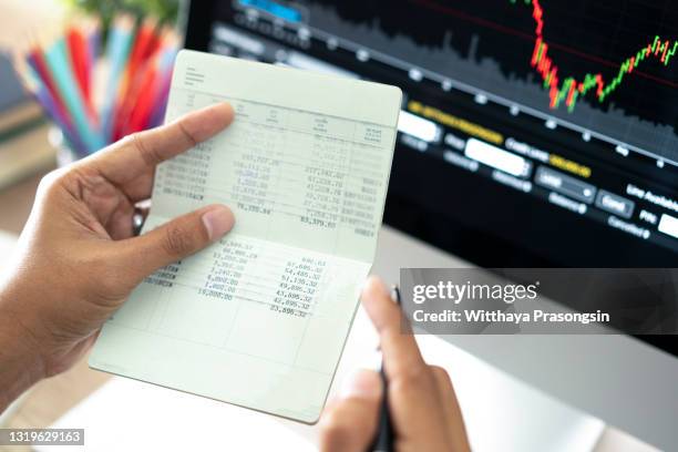 hands holding saving account passbook, book bank laptop background - cuenta de banco fotografías e imágenes de stock