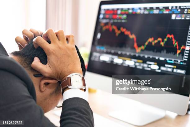 businessman grabs the head concept with business chart on scoreboard - 株価暴落 ストックフォトと画像
