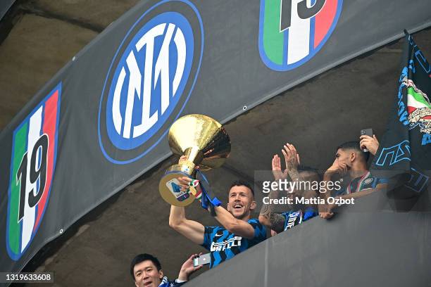 Ivan Perisic of FC Internazionale lifts the trophy towards the fans who are gathering outside the ground after the Serie A match between FC...
