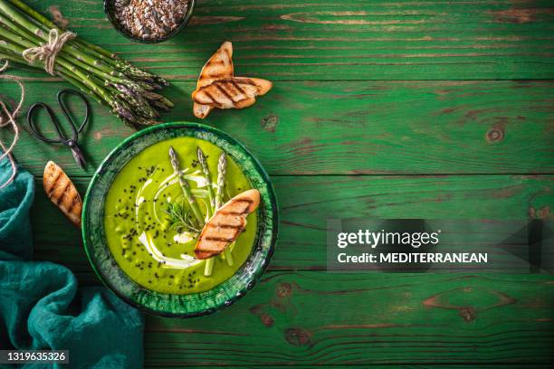 asparagus soup plate with ingredients and bread toasts on green wood - monochrome green stock pictures, royalty-free photos & images