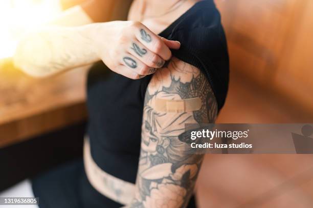 tätowierte frau mit verband aus impfstoff erschossen - tattoo shoulder stock-fotos und bilder