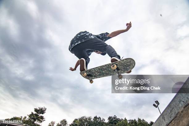 亞洲滑板手在動作中跳在空中 - skateboard 個照片及圖片檔