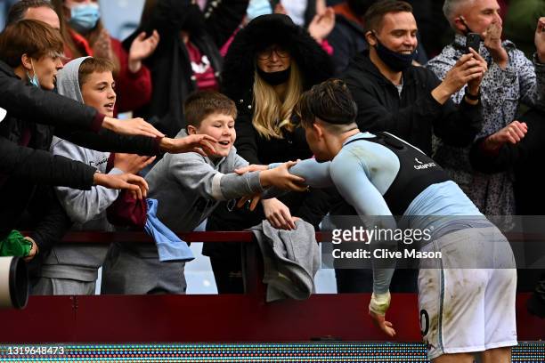 Jack Grealish of Aston Villa interacts with a fan following the Premier League match between Aston Villa and Chelsea at Villa Park on May 23, 2021 in...