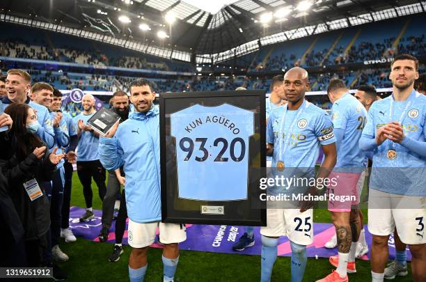 Fernandinho of Manchester City presents Sergio Aguero of Manchester City with a commemorative Manchester City shirt following his last game for...