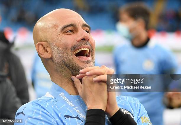 Pep Guardiola, Manager of Manchester City reacts after Manchester City are presented with the Premier League Trophy as they win the league following...