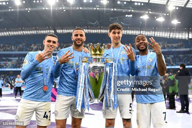 Phil Foden, Kyle Walker, John Stones and Raheem Sterling of Manchester City celebrate with the Premier League Trophy as Manchester City are presented...