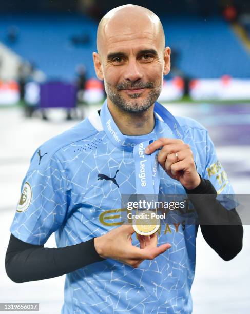 Pep Guardiola, Manager of Manchester City poses with his Premier League Winners' medal as Manchester City are presented with the Trophy as they win...