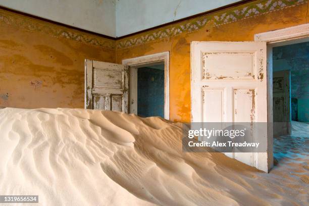 the interior of a building in the abandoned diamond mining ghost town of kolmanskop - sand pile stock pictures, royalty-free photos & images