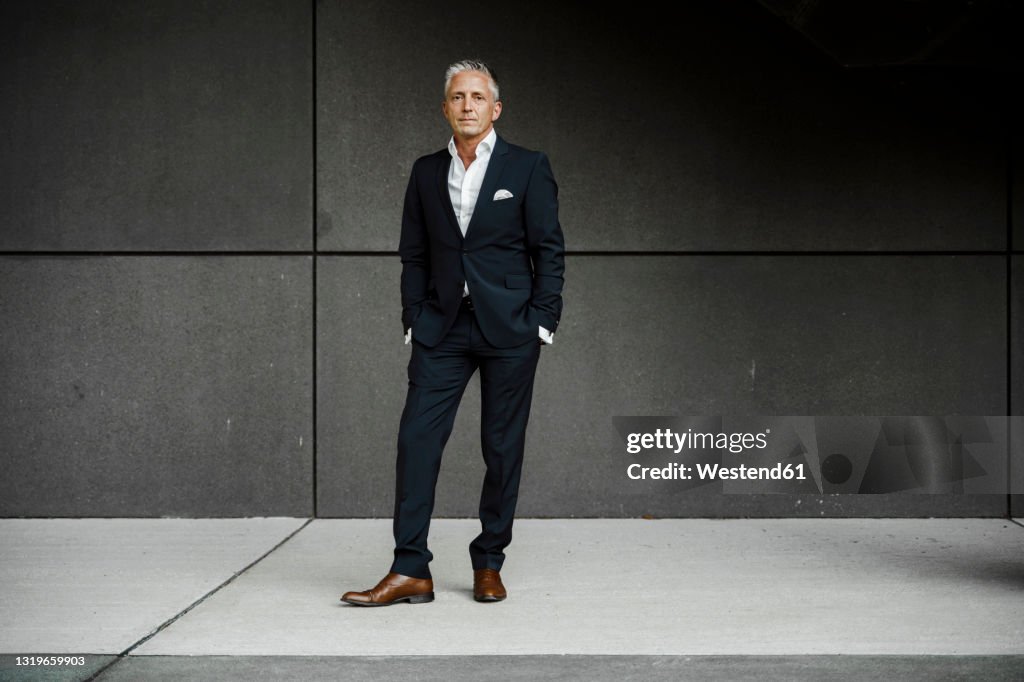 Businessman in front of gray wall