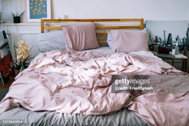 modern interiors: bedroom with pink bedding - messy bed stock pictures, royalty-free photos & images