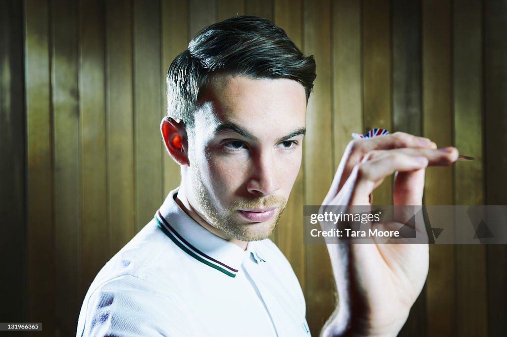 Young man aiming with dart