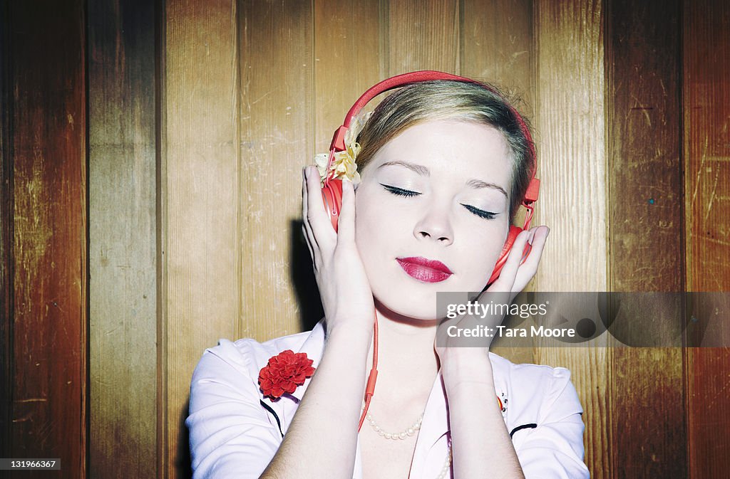 Young woman listening to music with red headphones