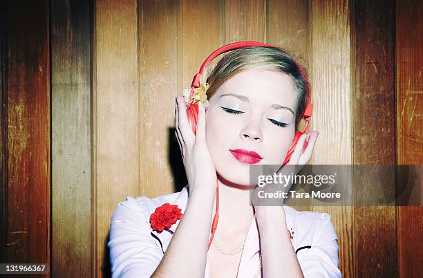 young woman listening to music with red headphones - headphones eyes closed stock pictures, royalty-free photos & images