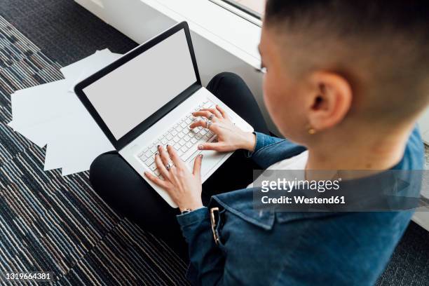 young businesswoman working on laptop in office - auf dem schoß stock-fotos und bilder