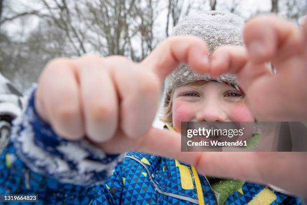 smiling boy gesturing with hands during winter - freezing hands stockfoto's en -beelden