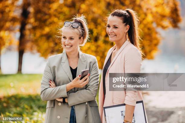 smiling women wearing smart casual standing together in garden - event planner stock pictures, royalty-free photos & images