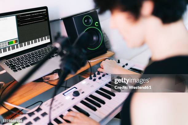 female musician playing piano while composing in studio - electric piano stock pictures, royalty-free photos & images