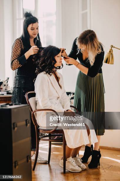 female hairdresser and make-up artist with bride at studio - bridal makeup stock pictures, royalty-free photos & images