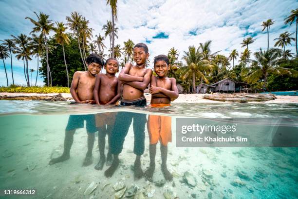 bajau children swimming in the sea of tropical island beach - pacific islands stock pictures, royalty-free photos & images