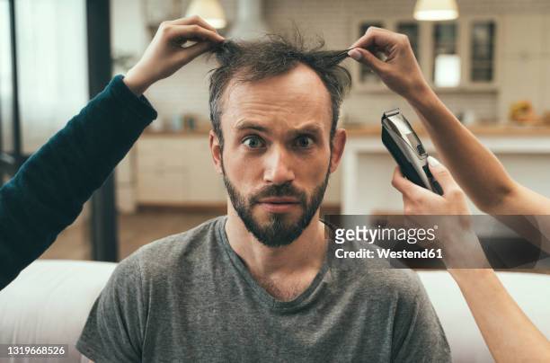 confused man having haircut at home - bad haircut photos et images de collection