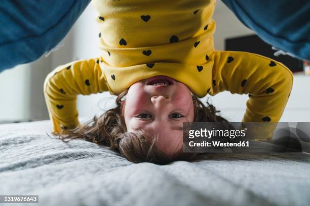 playful girl doing headstand at home - upside down stock pictures, royalty-free photos & images