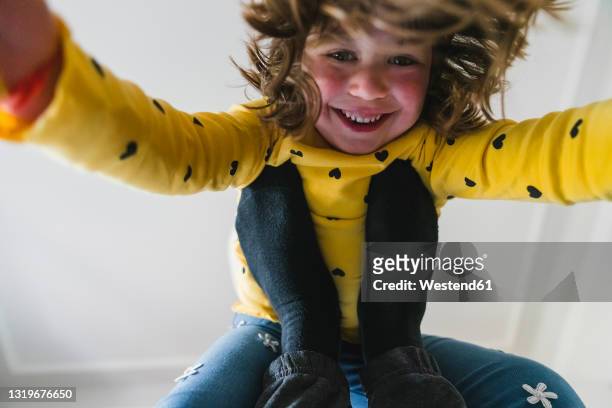 smiling girl leaning on legs at home - child and unusual angle stockfoto's en -beelden
