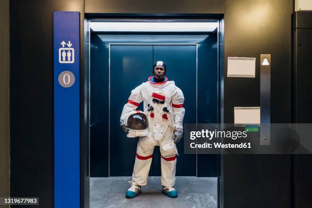 male astronaut with space helmet standing in elevator - astronaut potrait stock pictures, royalty-free photos & images