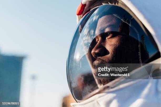 thoughtful astronaut looking away - ruimtehelm stockfoto's en -beelden