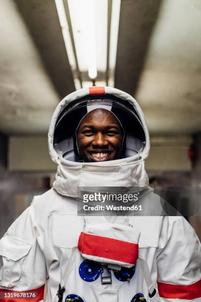 smiling male astronaut in basement - astronaut potrait stock-fotos und bilder