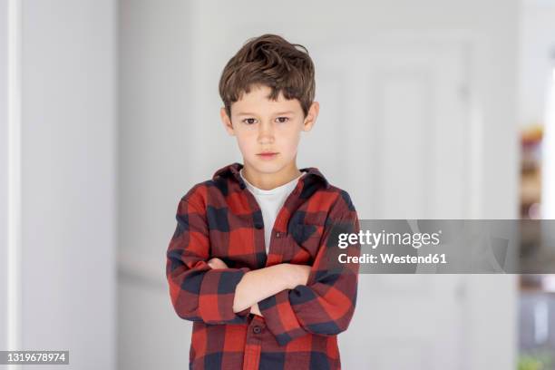 confident boy with arms crossed standing in front of wall - kids standing crossed arms stock-fotos und bilder