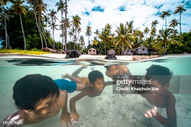 bajau children swimming in the sea of tropical island beach - bermuda snorkel stock pictures, royalty-free photos & images