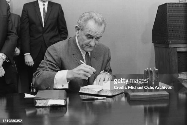 American politician Lyndon B Johnson , president of the United States, signing the Federal Budget at the White House in Washington, DC, 29th January...