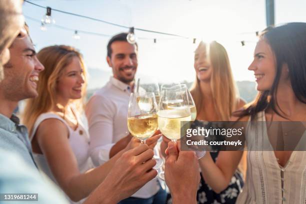 group of friends having drinks at sunset. - drink stock pictures, royalty-free photos & images