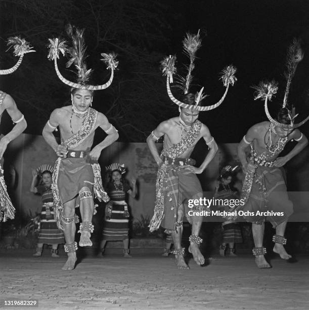 Naga tribespeople from Assam wearing elaborate headdresses as they give a demonstration of their dance in Delhi, India, circa 1960.