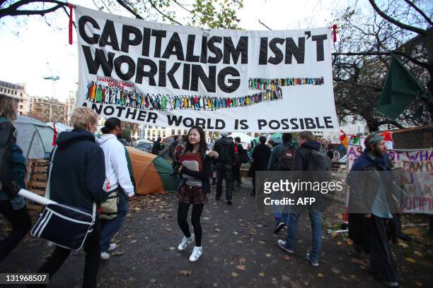 Students arrive at Finsbury Square in London on November 9, 2011 under a banner reading "Capitalism isn't working" for a demonstration against cuts...
