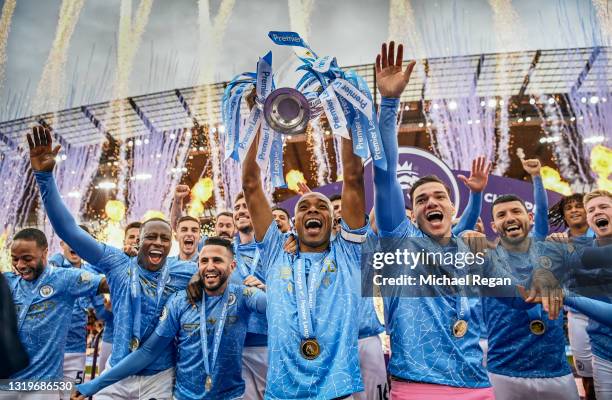 Fernandinho of Manchester City lifts the Premier League Trophy with team mates Benjamin Mendy, Riyad Mahrez, Ederson and Sergio Aguero as Manchester...