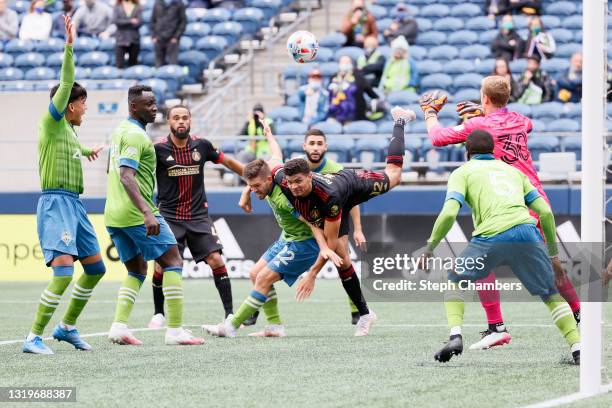 Miles Robinson of Atlanta United attempts to head the ball over Kelyn Rowe of Seattle Sounders during the second half at Lumen Field on May 23, 2021...