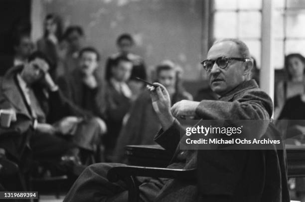 Polish-born American actor, director, and drama teacher Lee Strasberg teaching with students seated in the lecture hall in the background, at the...