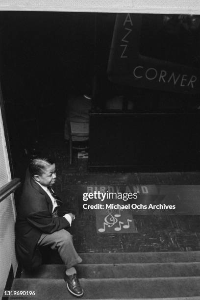 Young man standing at the bottom of the steps leading to the entrance to Birdland, a jazz club in the borough of Manhattan, New York City, New York,...