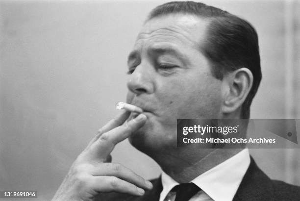 British playwright and screenwriter Terence Rattigan smoking a cigarette at an unspecified ship departure, location unspecified, November 1960.